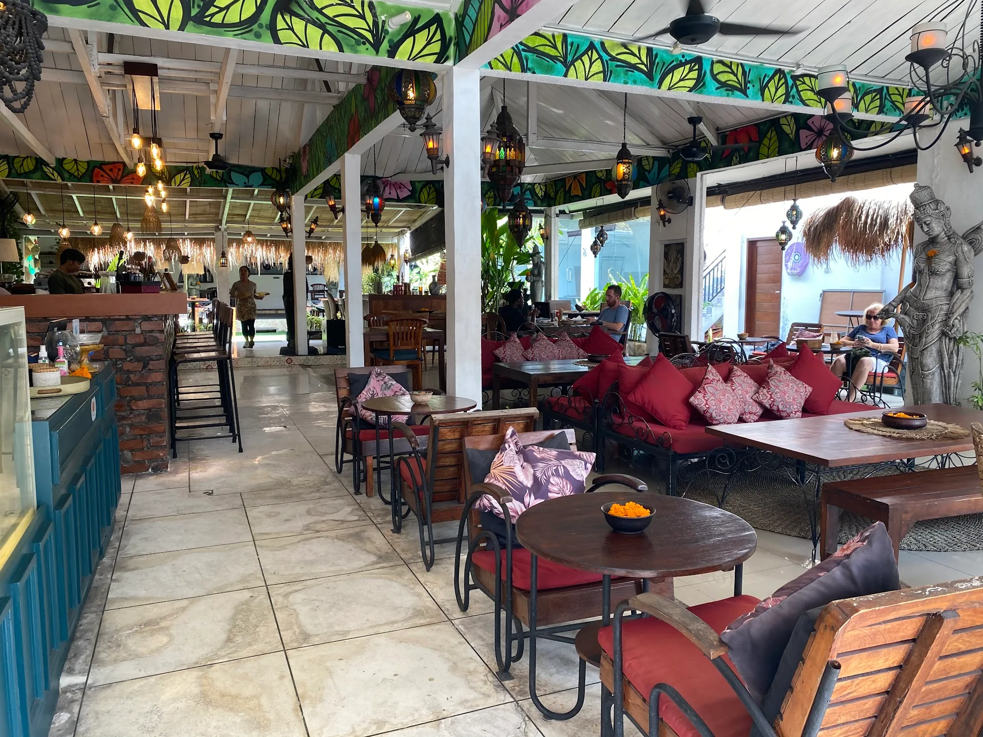 Wide interior view of Cafe Dunia's tropical seating area in Bali