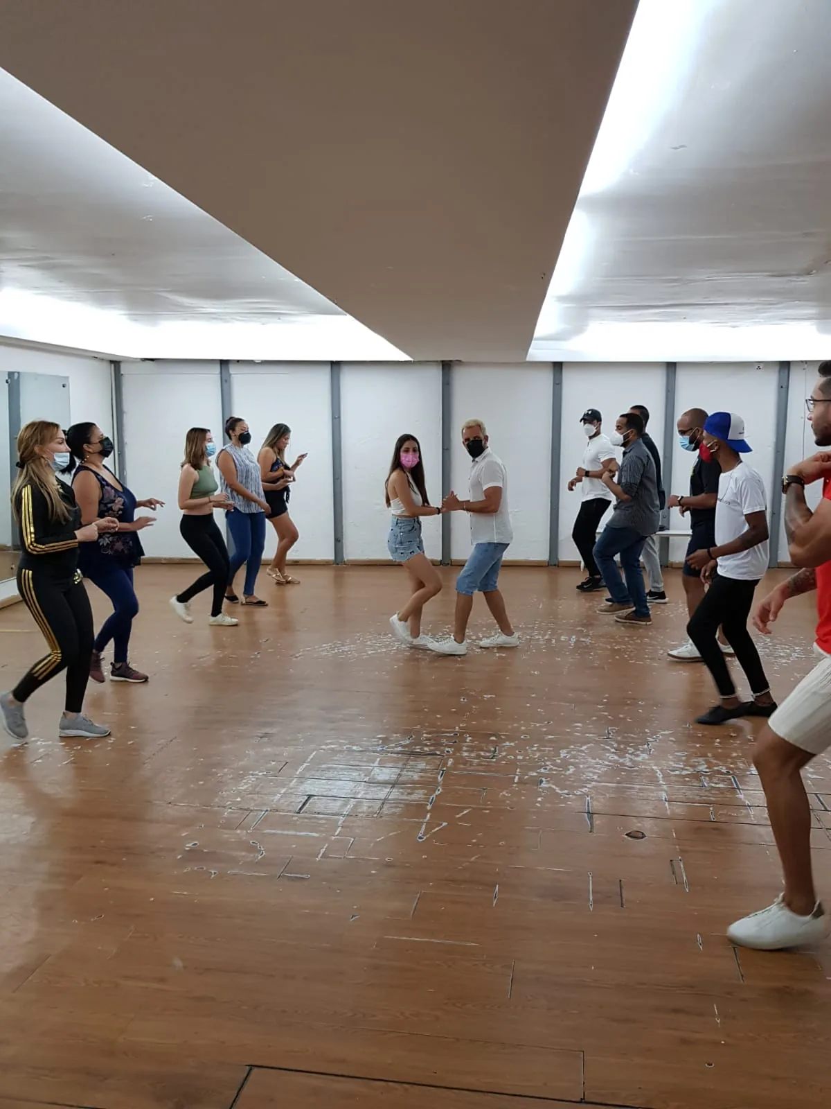 Group of dancers on the wooden floor at a salsa social at Muévete Studio in Santo Domingo