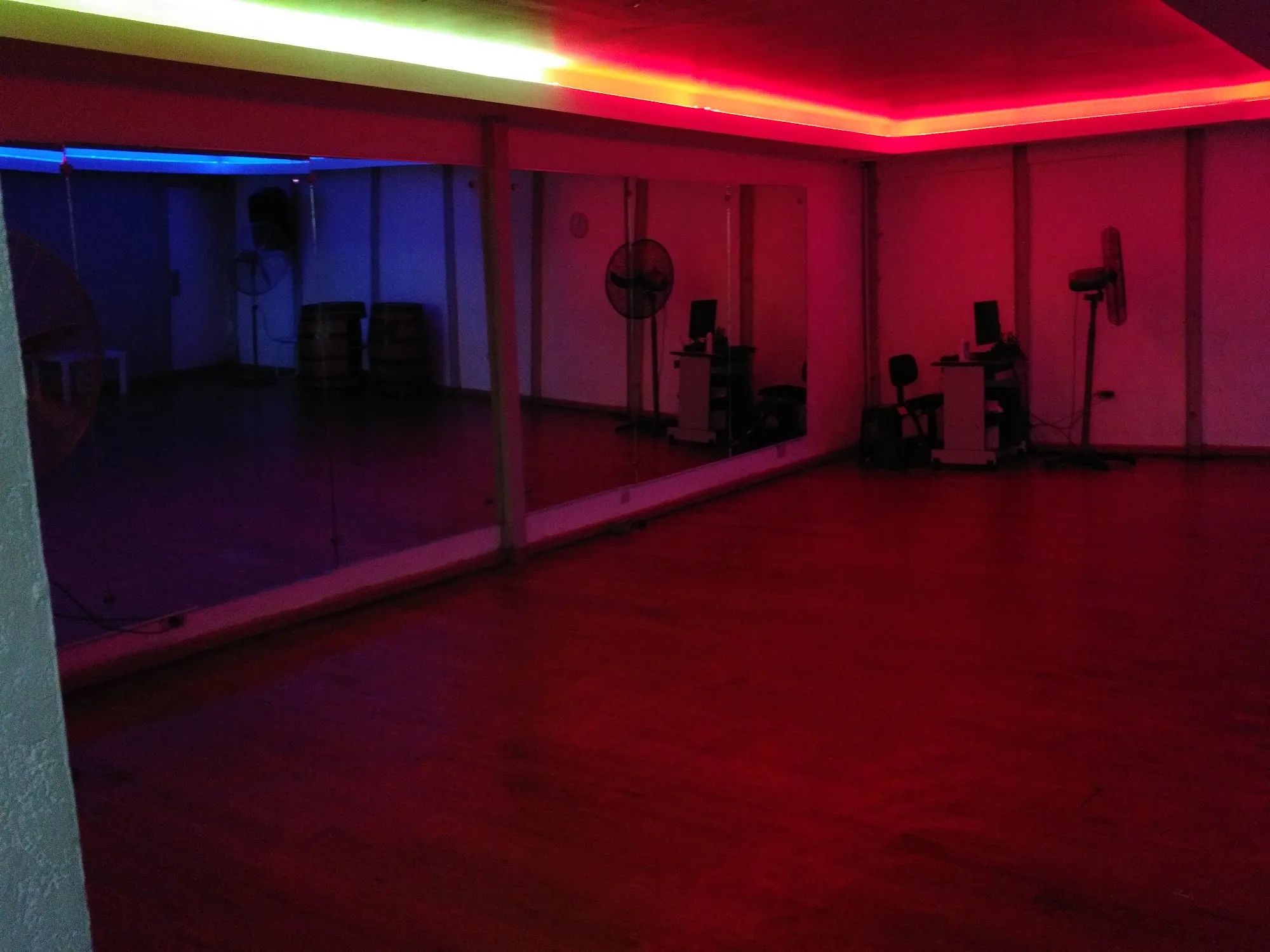 Muévete Studio dance floor with mirror wall and colorful neon lighting in Santo Domingo
