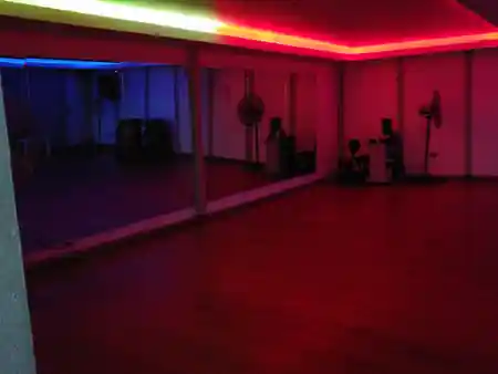 Muévete Studio dance floor with mirror wall and colorful neon lighting in Santo Domingo, salsa, bachata venue in Santo Domingo