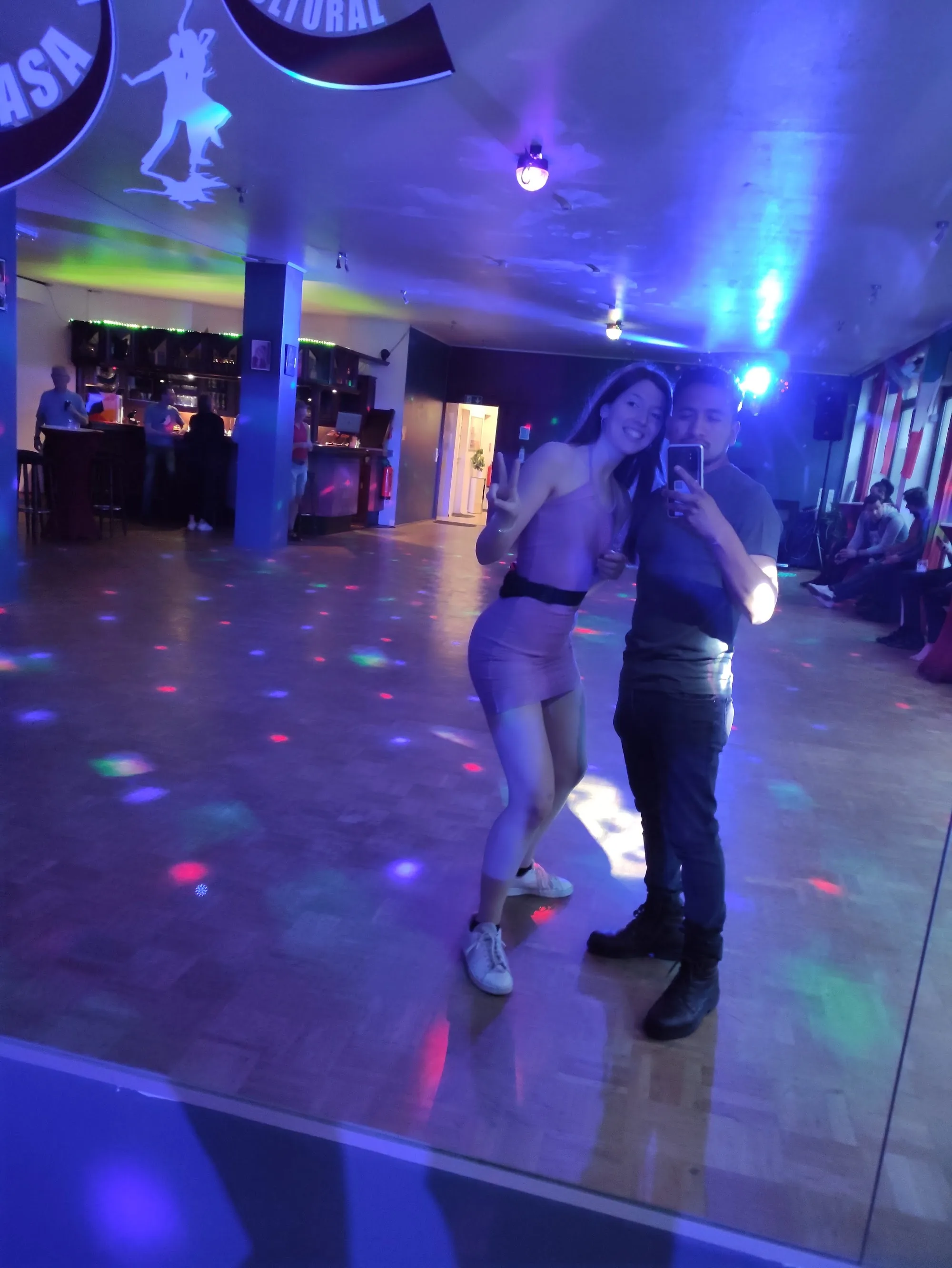 Couple dancing on colorfully lit dance floor at Casa Cultural e.V. Bremen