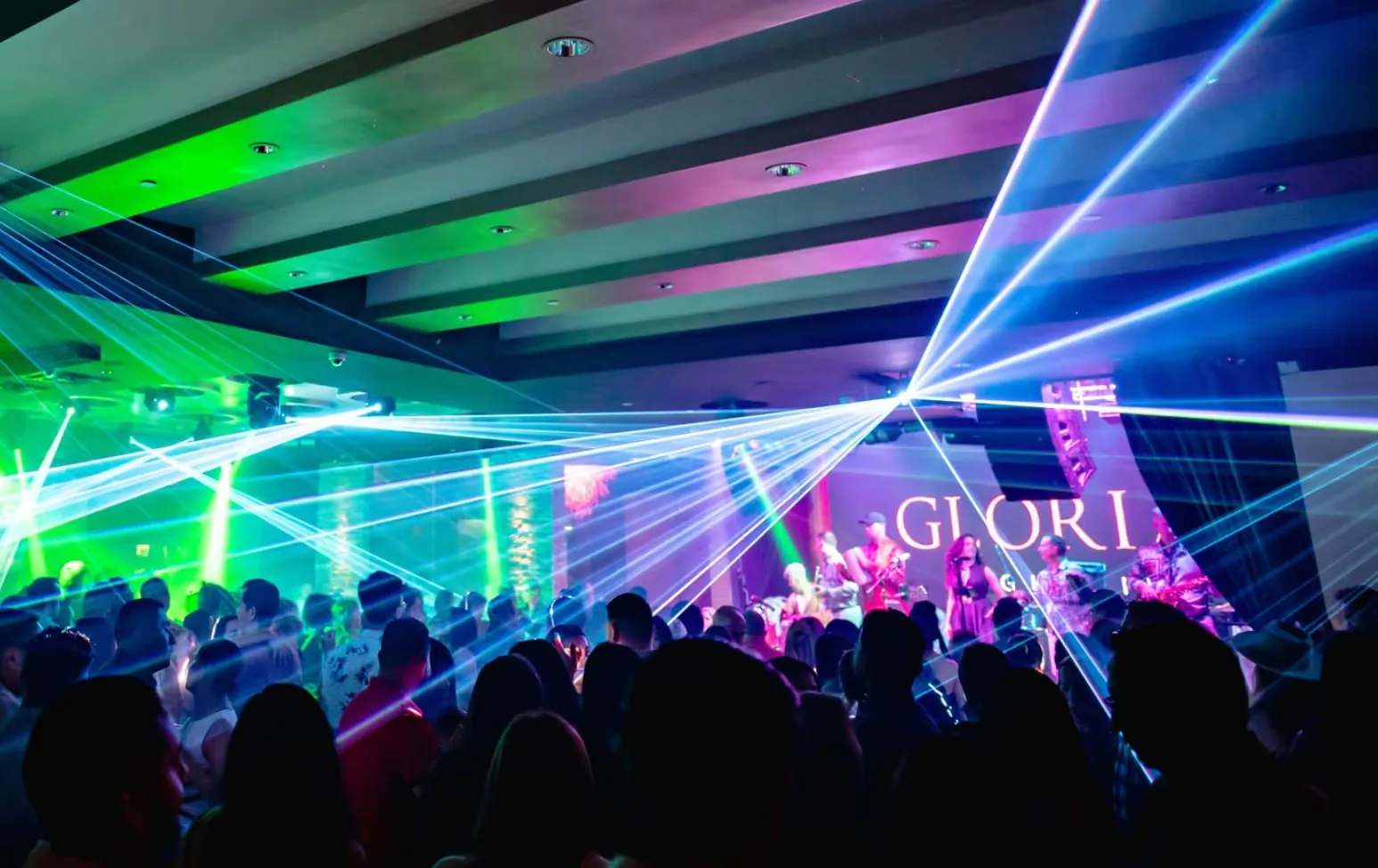 Packed dance floor with laser lights and live band at Gloria's Nightlife in Houston