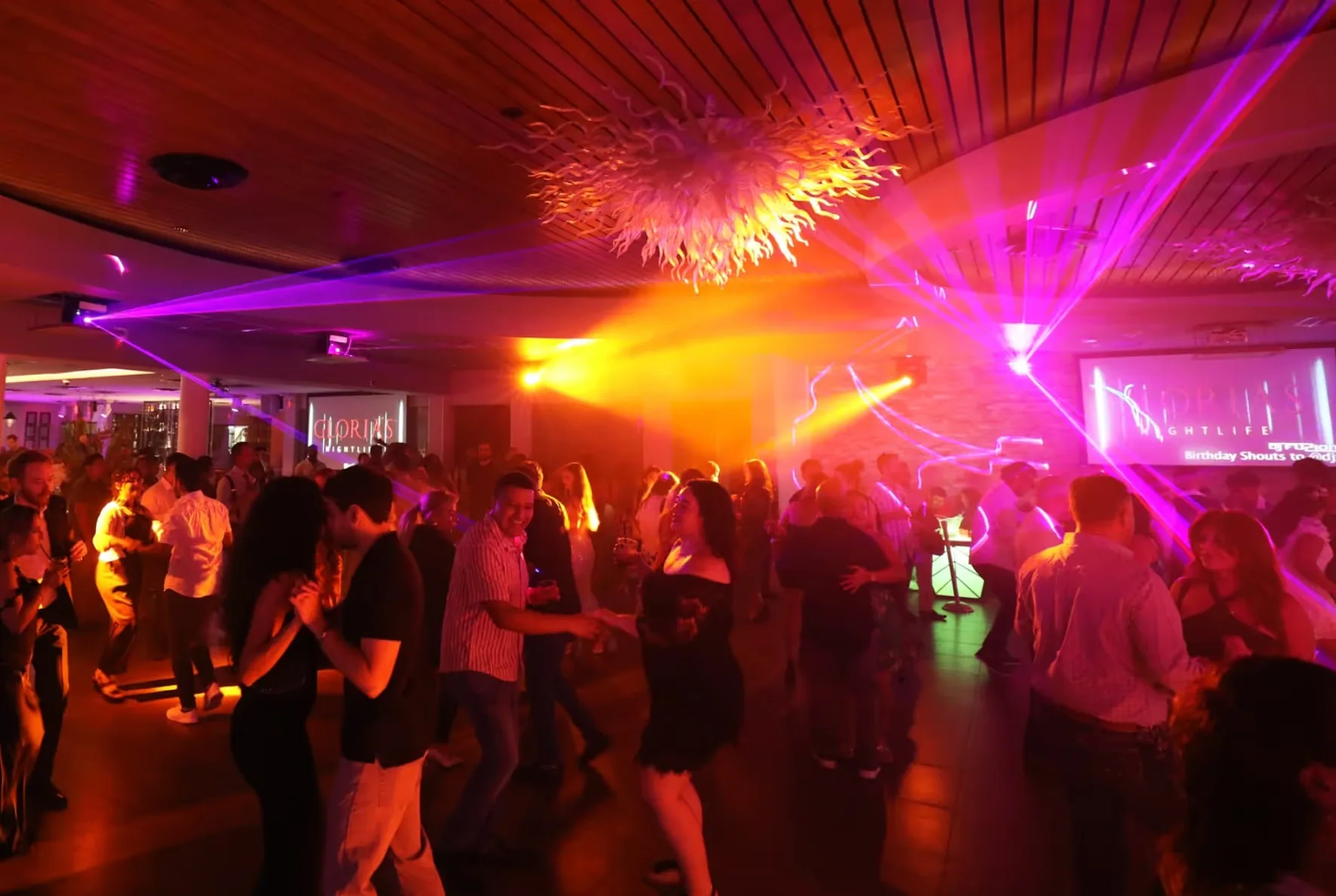 Couples dancing on Gloria's Nightlife dance floor under warm club lighting in Houston