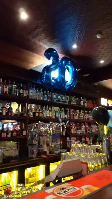 Mustang Bar Perth full bar interior with bottle wall and anniversary balloons — bachata, kizomba, salsa venue in Perth