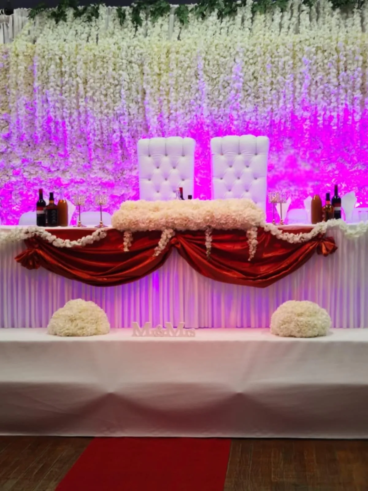 Event styling at IBEX Venue London with floral wall backdrop and pink uplighting