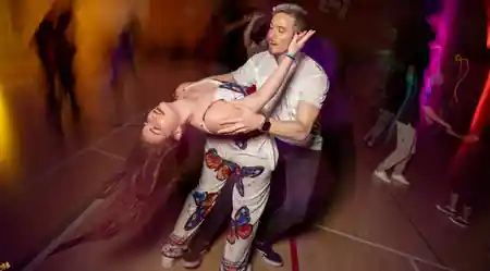 Couple performing a zouk dip under colorful lights at Ballie Ballerson in London