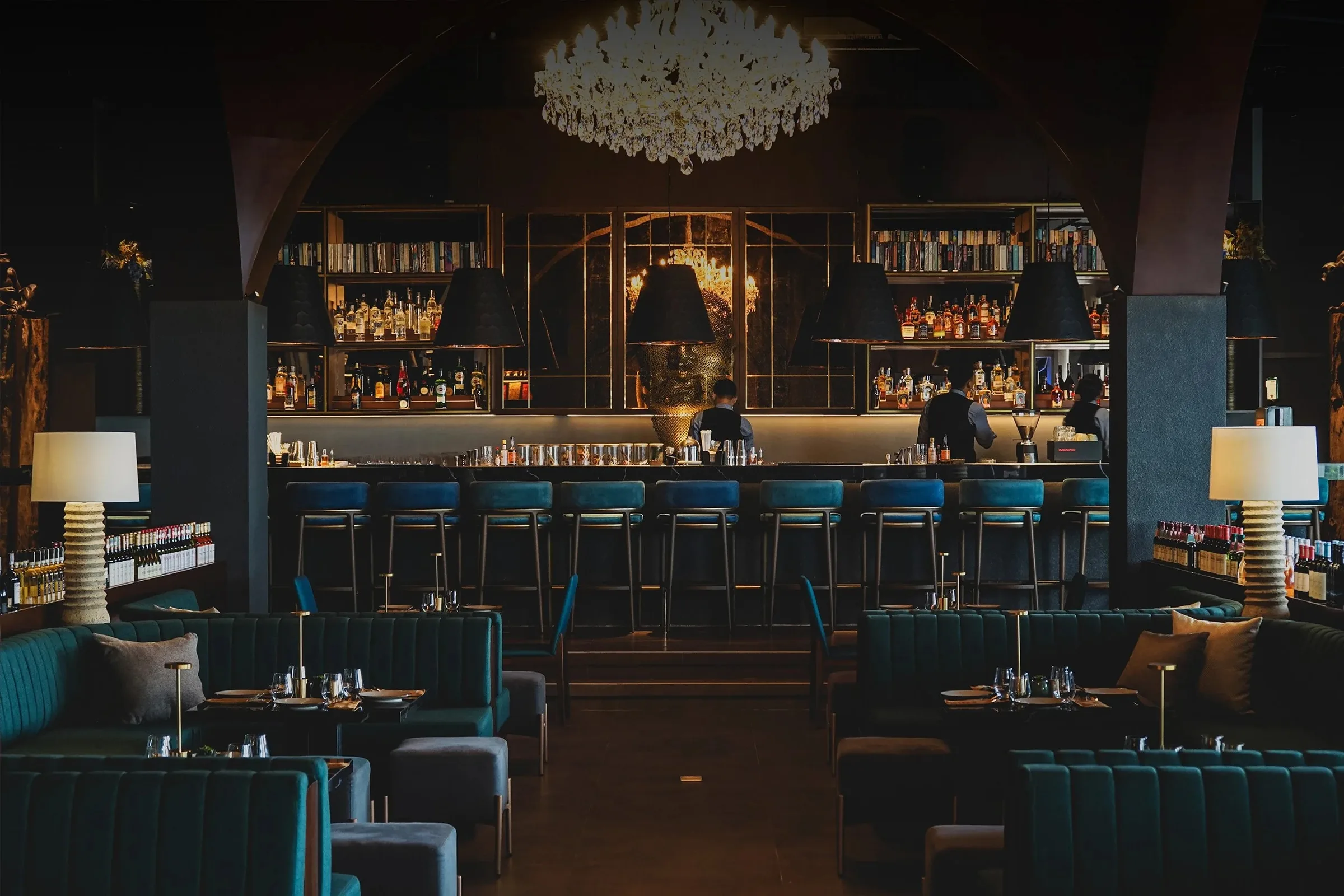 Elegant bar interior with chandelier and velvet seating at Midaz Bali