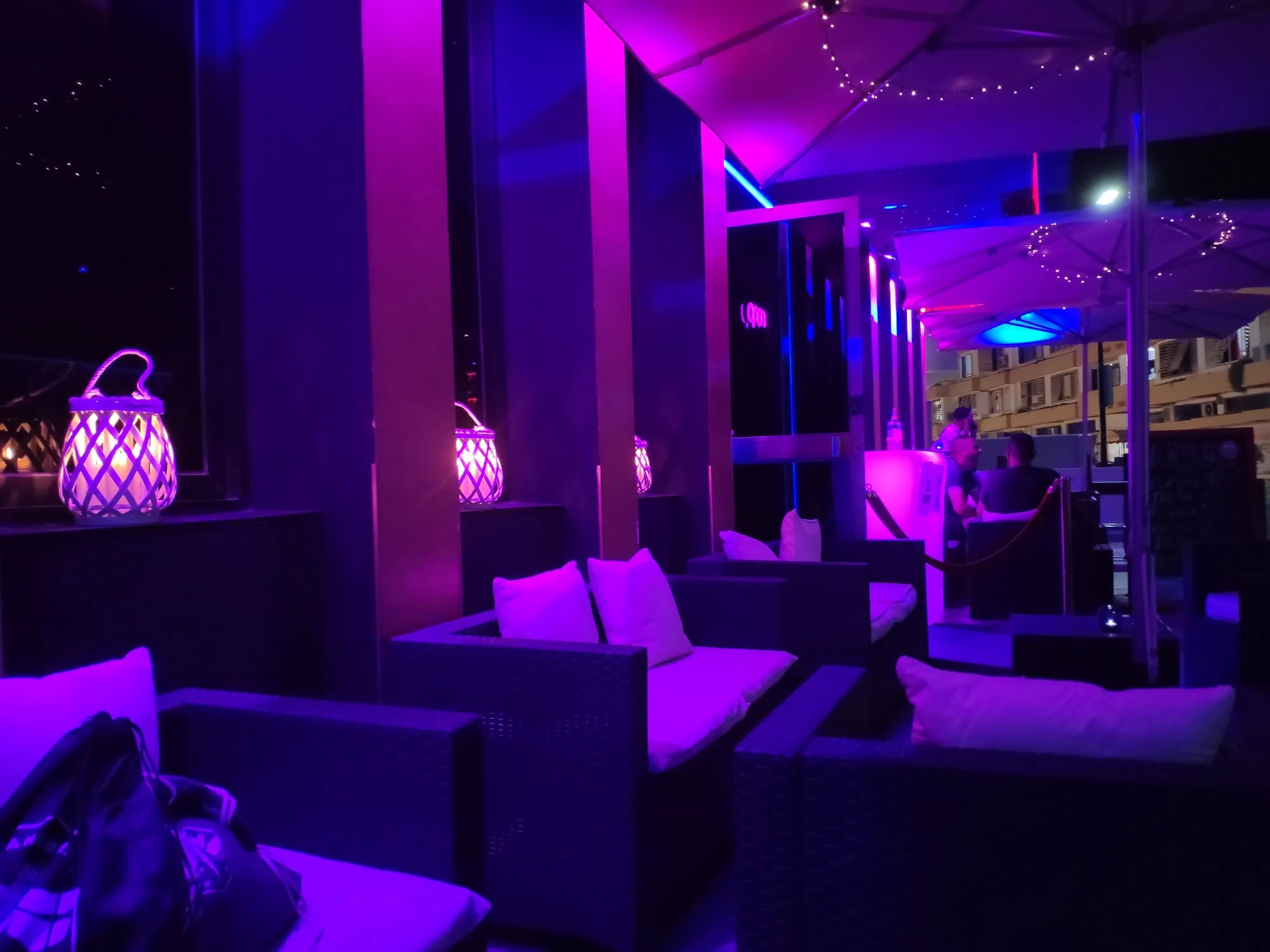 Mojito Club Barcelona terrace lounge seating with purple club lighting