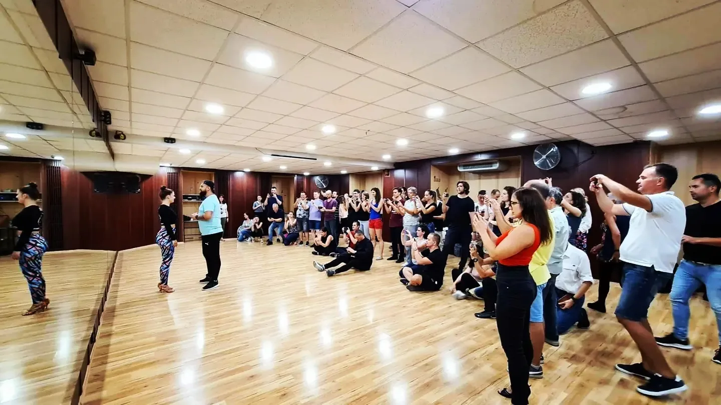 Dancers gathered around the wooden floor of the dance studio during a Latin dance social at Broadway Dance Center, Budapest — bachata venue in Budapest
