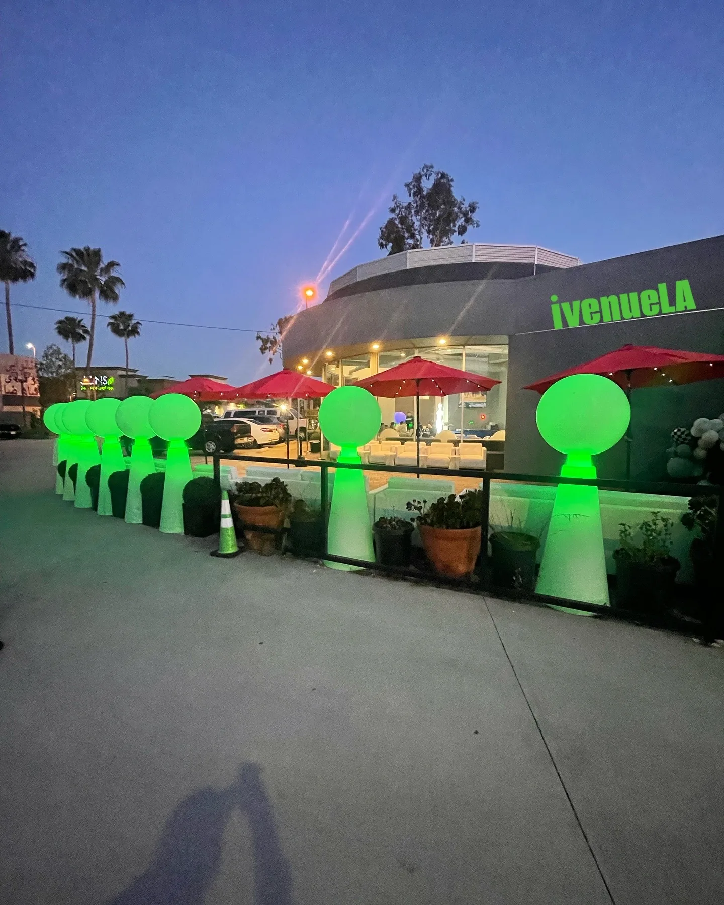 iVenueLA at dusk in Los Angeles with branded signage and glowing green-light decor on the patio — salsa, bachata venue in Los Angeles