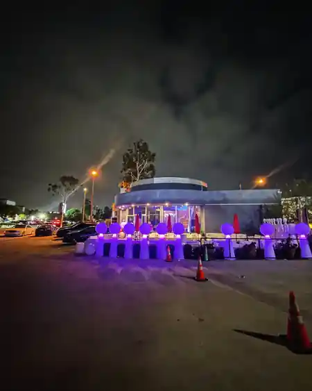 Night exterior of iVenueLA in Los Angeles with purple-lit decor on the patio, atmospheric event venue — salsa, bachata venue in Los Angeles