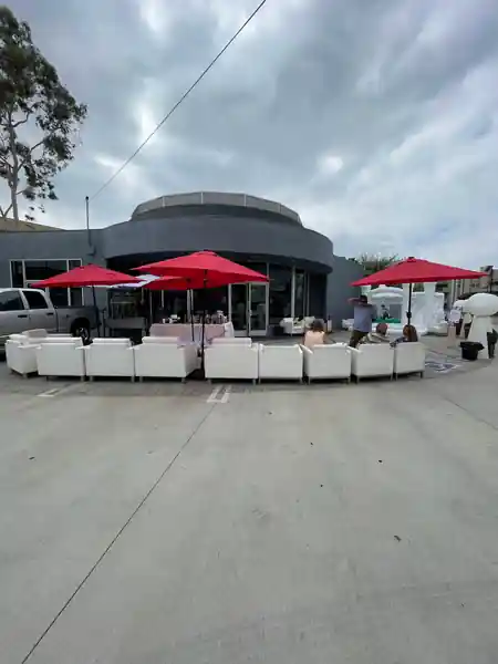 Outdoor lounge setup at iVenueLA in Los Angeles with white sofas and red umbrellas, event-ready patio — salsa, bachata venue in Los Angeles