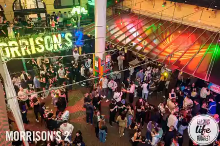 Overhead view of the Morrison's 2 courtyard signage and dance crowd in Budapest — bachata venue in Budapest