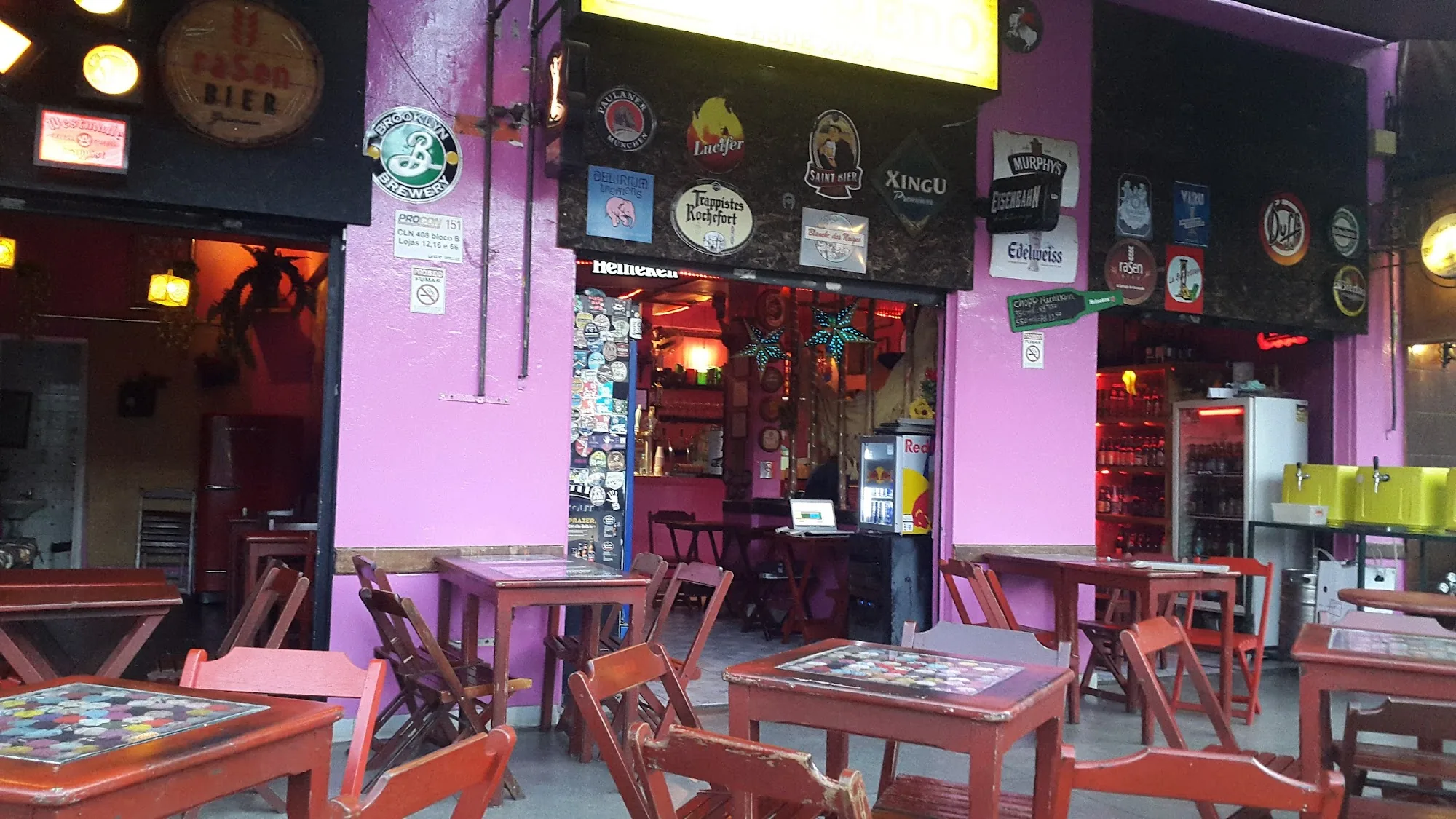 Purple and pink exterior of Godofredo Bar in Brasília with beer brand signs
