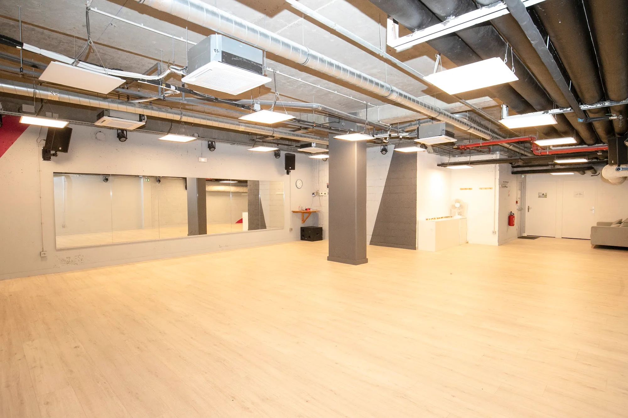 Spacious dance studio with wood floor and mirrored wall at Temple du Swing in Paris