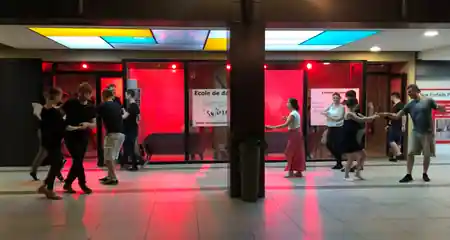 Couples social dancing in the lit corridor of Temple du Swing in Paris — zouk venue in Paris
