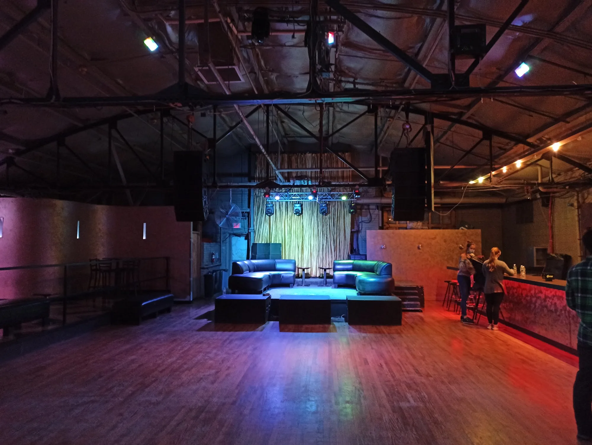 The main hall and hardwood dance floor with stage and lounge seating at La Rumba in Denver