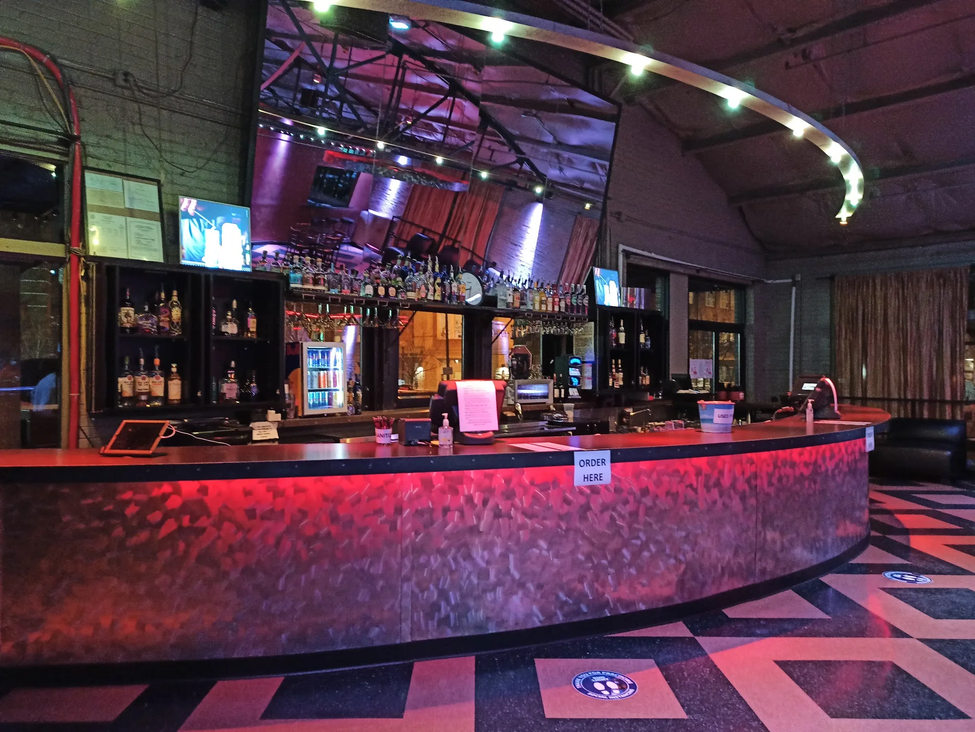 The curved main bar and patterned floor inside La Rumba, Denver's Latin dance club