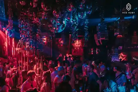 Energetic crowd filling the dance floor at Red Ruby Bali under disco balls and atmospheric red and blue club lighting — salsa, bachata, kizomba venue in Bali