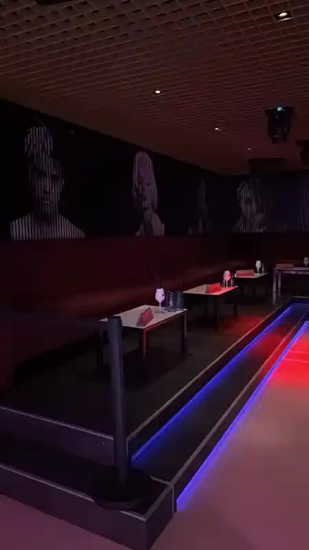 VIP booth seating area at Le Ciel with dramatic face murals on wall and blue/red LED dance floor edge — salsa, bachata venue in Bern