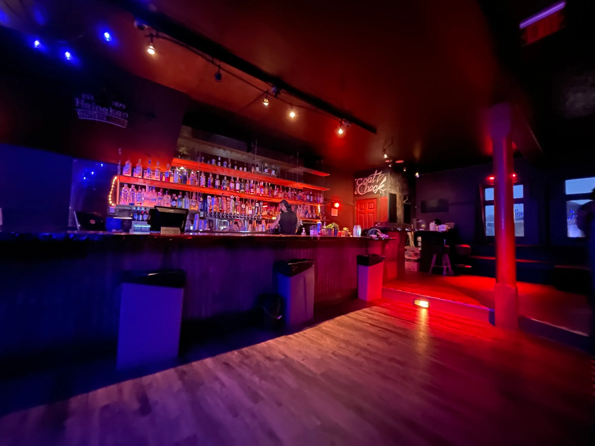 Bar and dance floor with red and blue club lighting at Neck of the Woods San Francisco