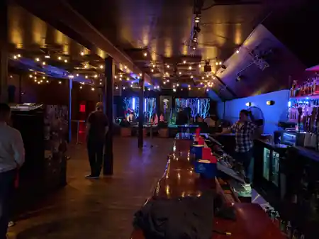 Wide interior view of bar and dance floor with string lights at Neck of the Woods San Francisco — salsa, bachata venue in San Francisco