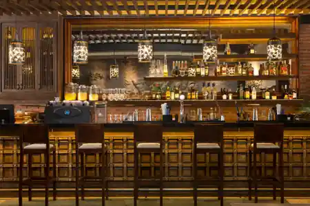 Warmly lit wooden bar with hanging lanterns at Enclave in Bali, Indonesia — salsa, bachata, kizomba venue in Bali