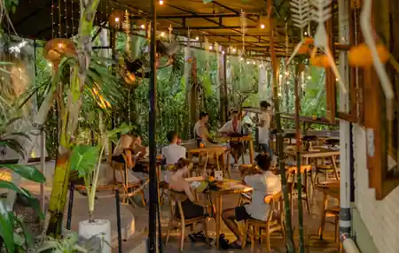 Open-air dining pavilion with fairy lights and tropical plants at Rolling Fork in Bali — salsa, bachata venue in Bali