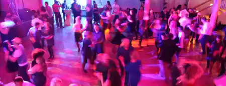 Packed Salsa social dance floor with motion-blur and pink lights at Salsamas in Munich