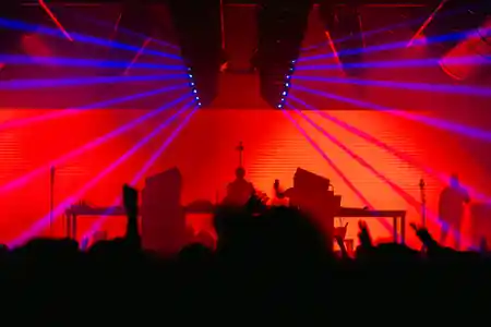 DJ with red and blue laser lights and crowd at Sala Pandora Seville nightclub — salsa, bachata venue in Seville