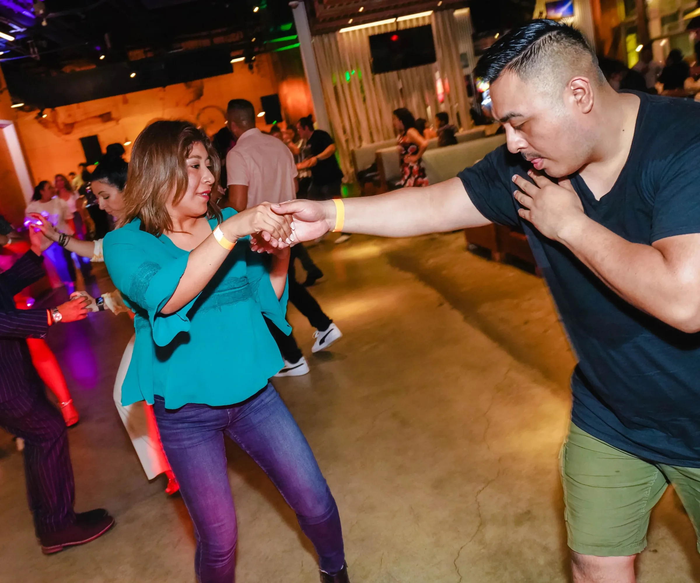 Salsa dancers on the dance floor under club lighting at Mariscos El Pacifico, Vista